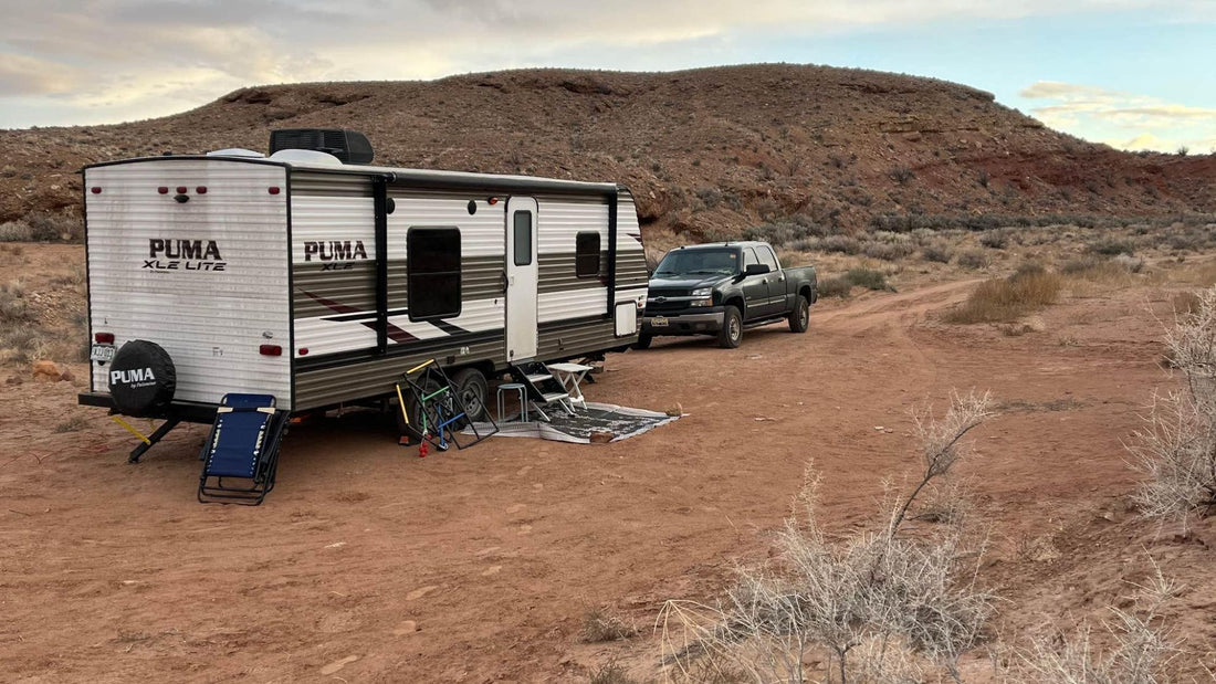 Travel trailer and truck dry camping in a desert campsite
