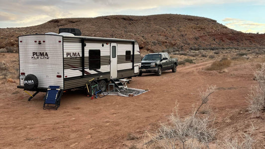 Travel trailer and truck dry camping in a desert campsite