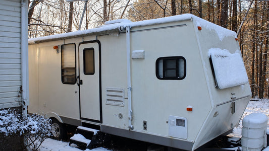 Travel trailer parked in snow with roof and side vents visible