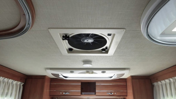 RV ceiling vent fan and skylight above wood cabinets