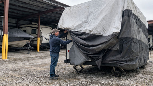 Travel trailer being uncovered after storage at an outdoor lot