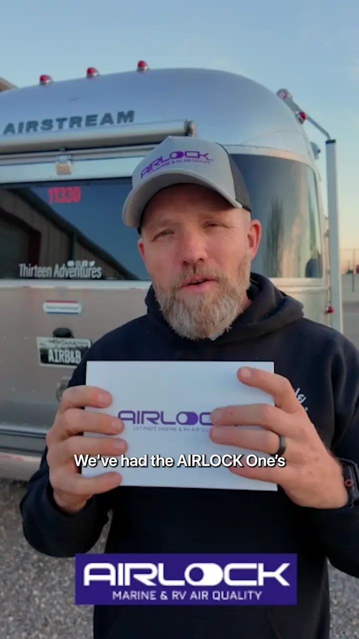 Brad holding an AIRLOCK One box in front of his Airstream